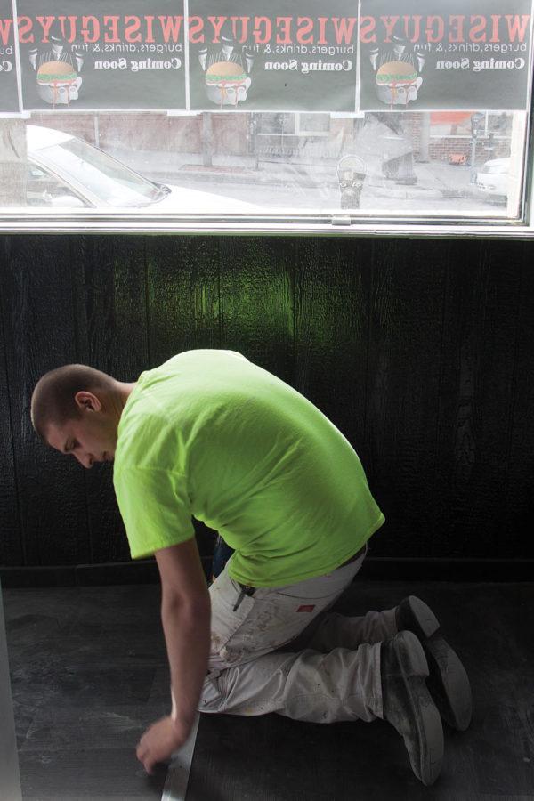 A construction worker makes some improvements on the flooring at the new burger restaurant, Wiseguys, located at 120 Welch Ave. The restaurant is expected to make its Ames debut on Thursday in Campustown.
