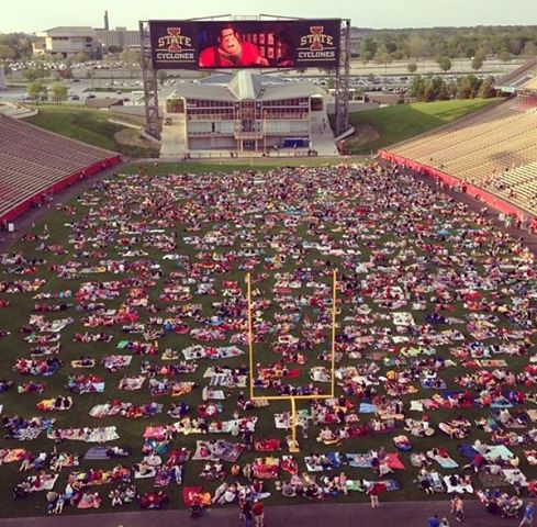 Friends and families gather at Jack Trice Stadium to watch a movie on the scoreboard. The movie event was the first one of its kind at Iowa State, and officials hope for it to be an annual event.
