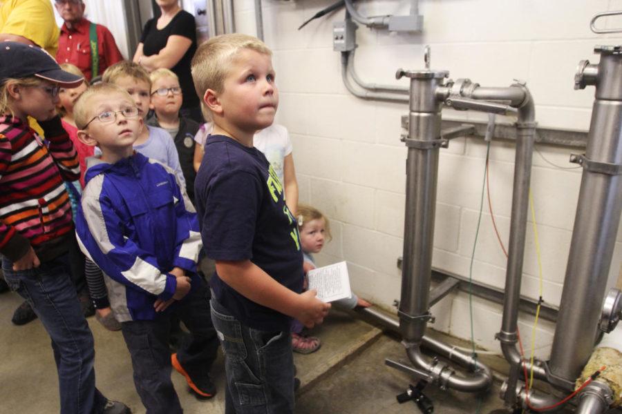 In the Milkhouse, milk travels throughout a system of pipes ending in a large storage tank known as a vat. When first entering the room, the milk comes directly from the cow at 101 degrees Fahrenheit, as this is the normal body temperature, and goes through two tube filters that clean out any contaminants. Above we see children crowding around to touch the warm pipe containing the 101 degree milk on June 7, 2013.