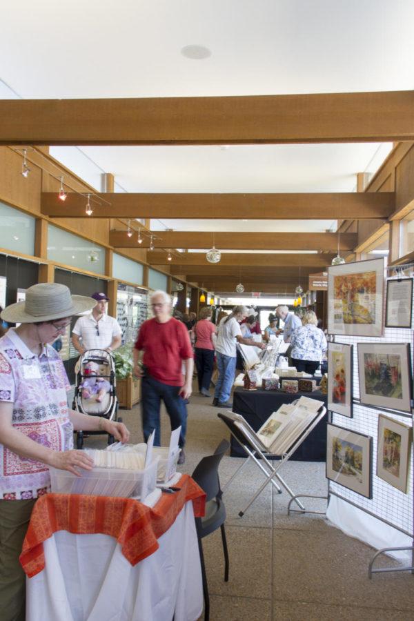 Shoppers look thorugh photos for sale during Reiman Gardens Art Fair. Reiman Gardens held its 10th annual Art Fair on Sunday, July 14. Over 50 artists had their work for sale and display around the gardens.
