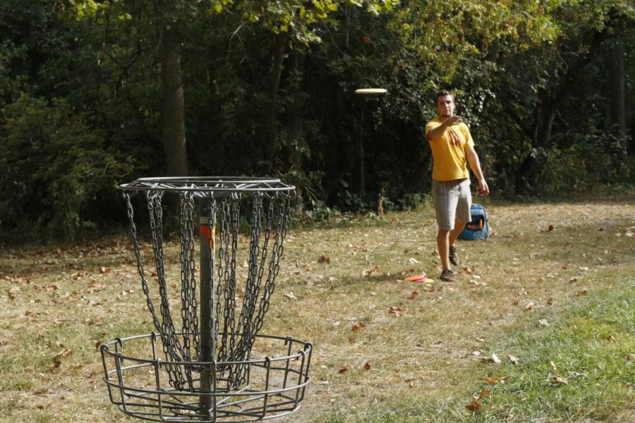 Adam Padget, senior in mechanical engineering, finishes tossing the disc during a putt at the Stable Run Disc Golf Course on Tuesday afternoon. Putting in disc golf is the act of standing in close proximity to the chains and lightly tossing the disc. 