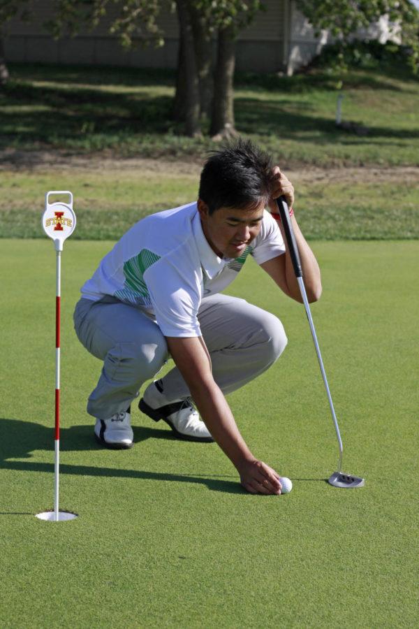 Ruben Sondjaja, freshman in psychology, sets up for practice at the ISU golf performance center on U.S. Highway 69 just south of Ames on Sept. 21, 2013.