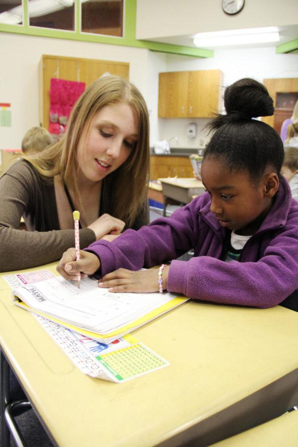 Jackie Schmidt, sophomore in kinesiology and health and member of Salt Company Student Fellowship, helps second-grader Zaria Seward try to solve a math question and gives some tips on spelling words during a study time at Kate Mitchell Elementary on Dec. 5. The Salt Company is a ministry of Cornerstone Church and a group at Iowa State, and some members of the group volunteer their time to help teachers at Kate Mitchell Elementary. Schmidt helps second-grade teacher Ashley Hokel with her class on Wednesday mornings.
