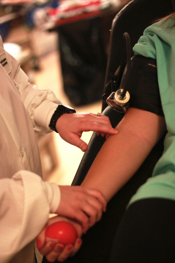 A Red Cross nurse locates the vein of a student about to donate on Tuesday, Oct. 8. Often the process of checking a donor in, setting them up on a bed and preparing them for the donation to start takes longer than the donation itself.