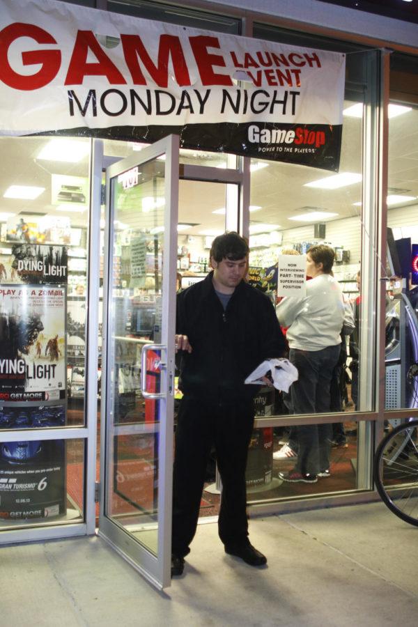 James Woodward, food service employee at Iowa State, carries out his copy of Battlefield 4 at GameStop during the midnight release of BF4, WWE 2K14, and Assassin’s Creed IV: Black Flag on Monday night. 