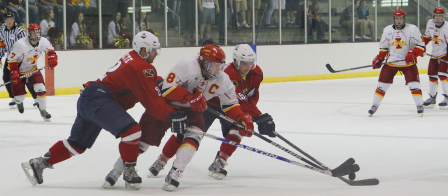 Senior forward Mark Huber attempts to break free from two North Iowa defenders on Sept. 27 at Ames/ISU Ice Arena. The Cyclones took down the Bulls 4-2.