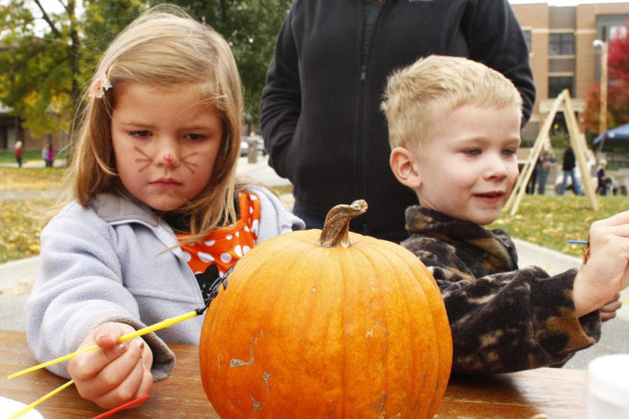 Caroline Brandon, 5 years old, and Michael Kundel, 4 years old, paint pumpkins on Sunday, Oct. 20, on the Sigma Alpha Epsilon driveway.