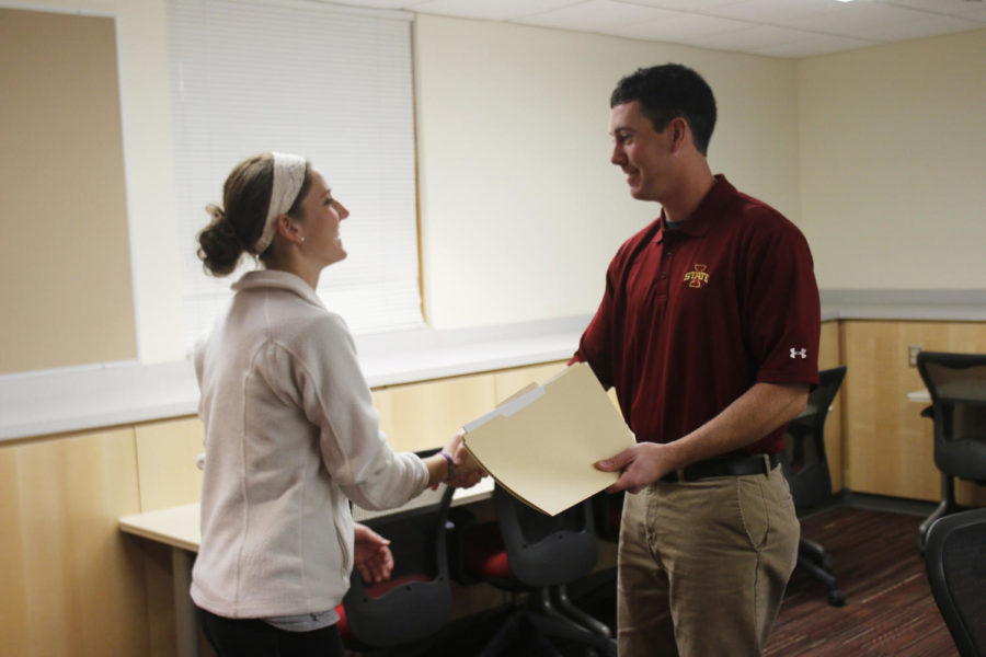 Sports Clubs Coordinator Landon Wolfe shakes hands with Erica Tucker, senior in kinesiology and health. Tucker is also the co-president of the womens soccer club. 