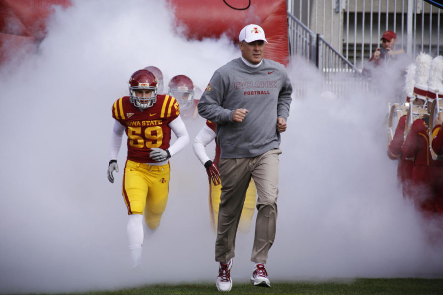 Coach Paul Rhoads runs onto the field with the team before the game against Oklahoma State on Saturday, Oct. 26, in Jack Trice Stadium.