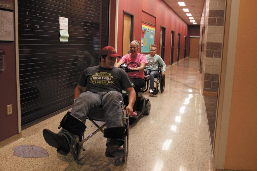 Sam Mereness, junior in mechanical engineering, tries out a wheelchair with some of his friends at the Step Into My World event, part of Disability Awareness Week. The event included discussions on the challenges people with disabilities face, and gave non-disabled persons a chance to see what it is like living various disabilities. Photo: Lyn Bryant/Iowa State Daily