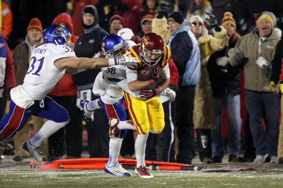 Wide receiver Justin Coleman pushes on as two Kansas defensive players tackle him from behind during the game on Nov. 23 at Jack Trice Stadium. The Cyclones won against the Jayhawks with a final score of 34-0.