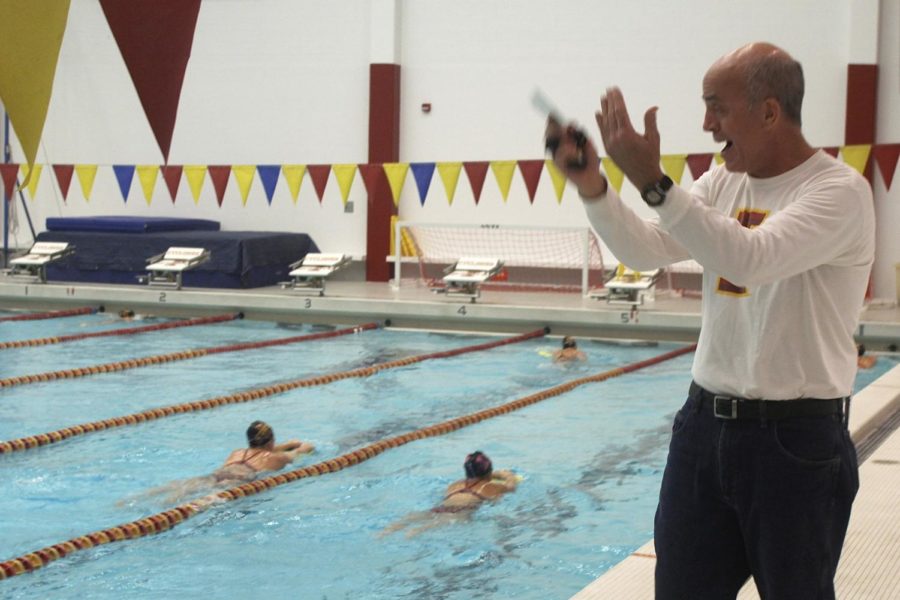 Head Coach Duane Sorenson communicates with the womens swimming and diving team using hand signals to compensate for limited communication in the sport. 
