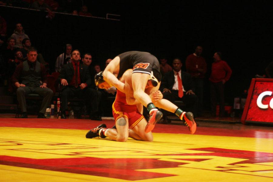 Redshirt junior Michael Moreno flips his Oklahoma State opponent Tyler Caldwell during the wrestling meet Feb. 3, 2013, at Hilton Coliseum.