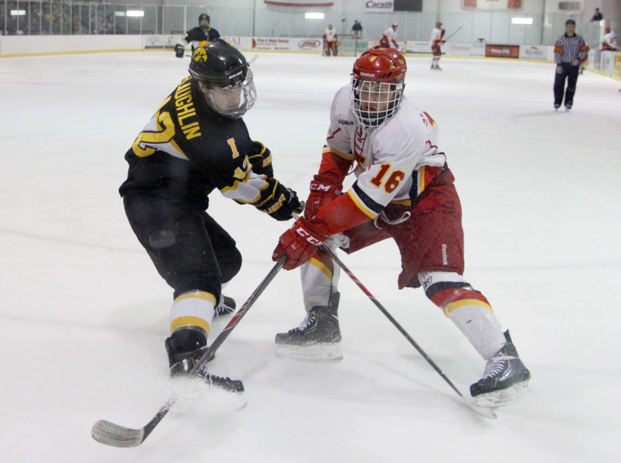 Junior forward Seth Serhienko and Hawkeye freshman defender Tim McLaughlin go after the puck on Jan. 24, 2014, at the ISU/Ames Ice Arena. Serhienko scored the only goal in the game.