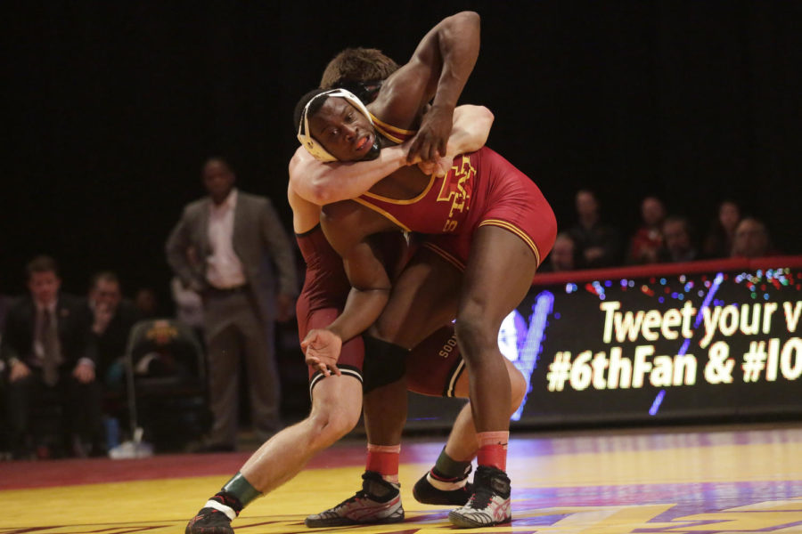 Redshirt junior Kyven Gadson, 197-pound weight class, grapples with his opponent to swing him around Jan. 12 at Hilton Coliseum. Gadson won in overtime. Iowa State lost the duel to Oklahoma 11 to 27.
