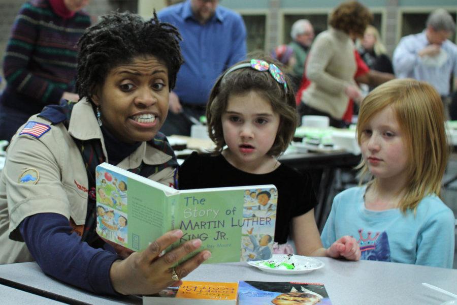 Katrina Williams reads to Lucy (left) and Georgia (right) during the Ames Community Celebration in honor of Dr. Martin Luther King Jr. at Ames Middle School on Jan. 20. Williams is originally from Atlanta and has previously worked with Kings sister Christine King Ferris. She comes to the community celebration each year to share Kings story and message.