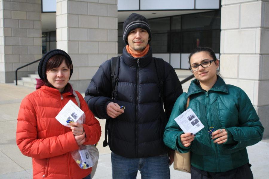 Ukrainian students stand outside of Parks Library handing out ribbons and brochures to bring awareness to the current situation in their home country of Ukraine. From left to right: Nataliia Sukhinina, Volodymyr Sukhinin, Shalika Khindurangala.