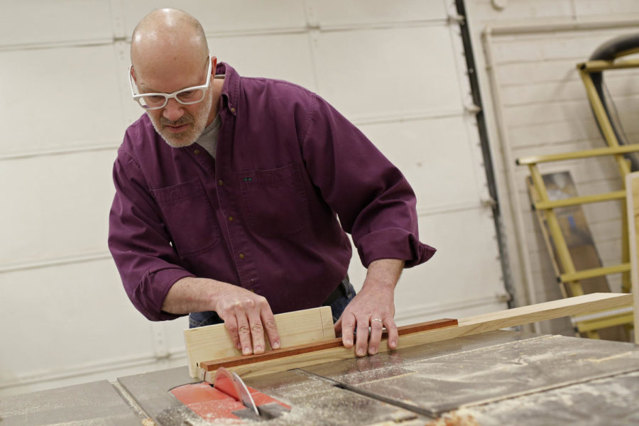 Custom guitar maker and woodworker Peter Malinoski, visiting artist-in-residence, cuts out the neck of the guitar on day one of the workshop. He sealed the fretboard of the guitar to another piece of wood to create the neck.