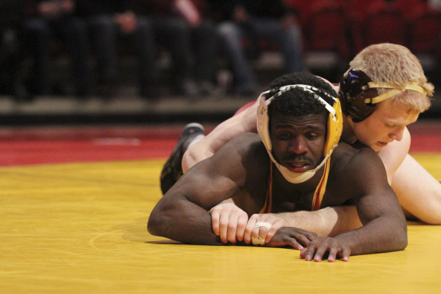 125-pound sophomore Earl Hall works to get out of the grasp of Sam Brancale during the dual versus Minnesota on Feb. 23 at Hilton Coliseum. Hall pinned Brancale in the third period. The Cyclones lost to the Golden Gophers 12-27. 