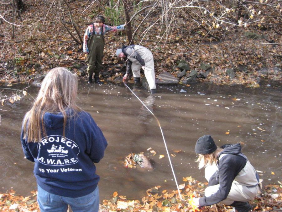 Mary Skopec, Iowater trainer from Iowa Department of Natural Resources, trains ISU students Win Cowger, Zachary Schlake and Ethan Rietz on checking the water quality of the streams on campus. 
