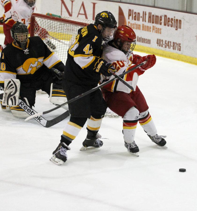 Freshman forward Chase Rey and Iowas Tim McLaughlin go after the puck near the goal on Jan. 24, 2014, at the ISU/Ames Ice Arena. The Cyclones scored the only goal that night.
