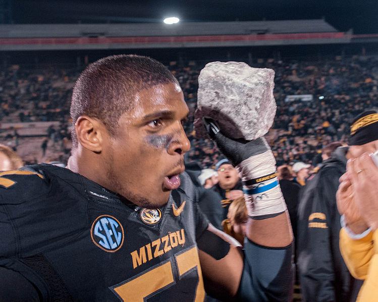 Fans flock senior defensive end Michael Sam as he carries his souvenir [a rock from the rock M at Memorial Stadium] after the win over Texas A&M.