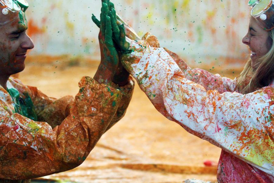 Ahmad Almansouri, junior in architecture, and Elliejo Lafever, senior in interior design, clasp paint-covered hands during a yearly stress-relieving event that promotes creative expression. Students wore body suits and covered themselves in tempera paint.