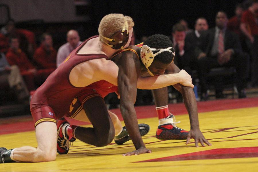 125-pound sophomore Earl Hall works to get out of the grasp of Sam Brancale during the dual versus Minnesota on Feb. 23 at Hilton Coliseum. Hall pinned Brancale in the third period. The Cyclones lost to the Golden Gophers 12-27. 