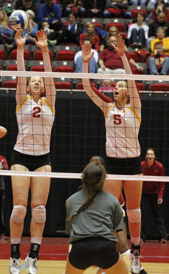 Junior Mackenzie Bigbee, left, and sophomore Natalie Vondrak, right, block the ball in the second game of the volleyball tournament on Saturday, April 5 at Hilton Coliseum.