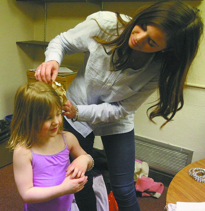 Senior Emma Garner tests out a hair accessory from her childrens line on her model Mallory on March 24. Garner is one of two people submitting a chidlrens line for the Fashion Show on April 5. 