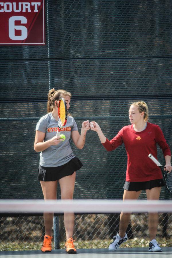 Freshman Samantha Budai and junior Ksenia Pronina bump fists during the doubles portion of a tennis match against Texas Tech. 