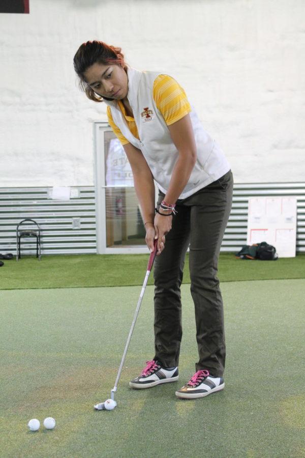 Prima Thammaraks, senior from Thailand, practices a put in the new Iowa State Golf Performance Facility south of campus. 