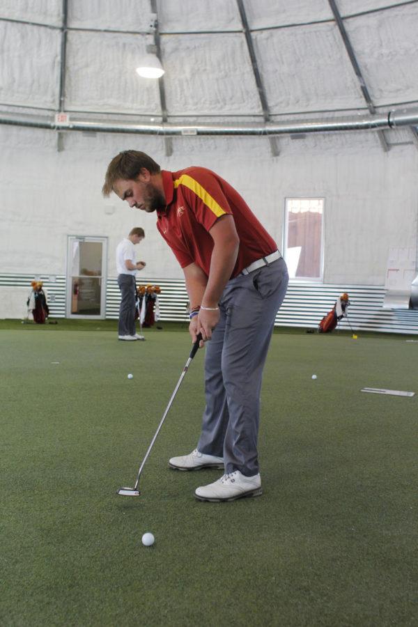 Junior Sam Daley practices his putt Feb. 26 at the golf teams indoor practice facility.