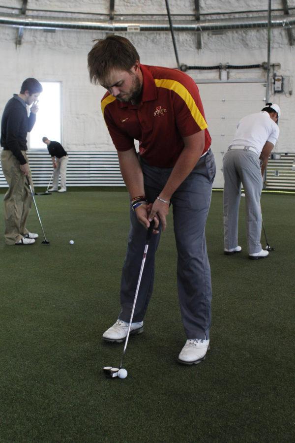 Junior Sam Daley practices his putt on Feb. 26 at the golf teams indoor practice facility.