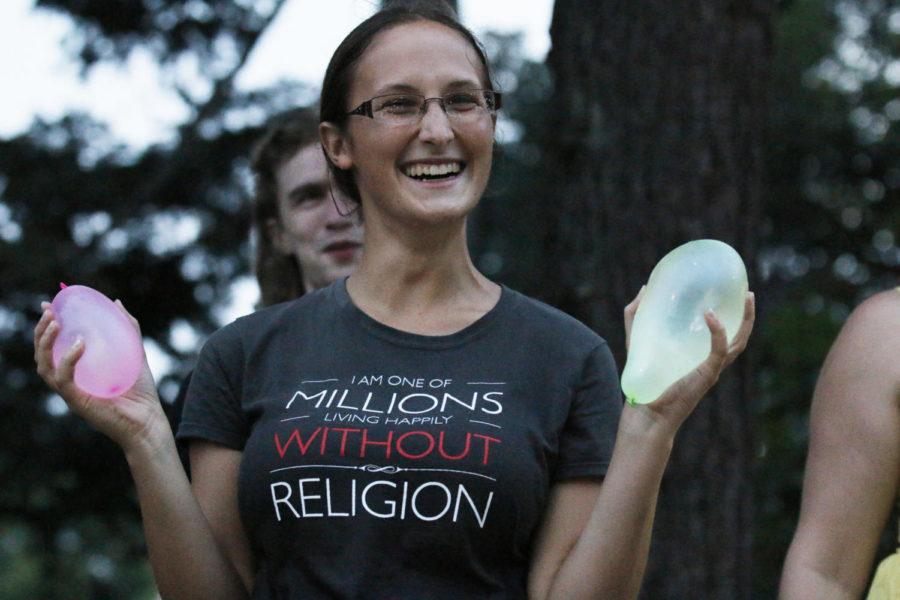 Dana Korneisel, senior in geology, asks students attending The Salt Company event on the south Campanile lawn to "bless an atheist" with water balloons. Korneisel, part of the Atheist and Agnostic Society, sold water balloons for $1 each to those willing to throw them at her.