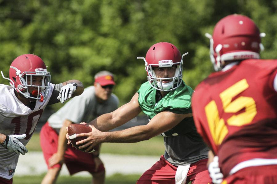 Redshirt junior quarterback Sam Richardson hands off the ball at the first fall practice on Aug. 4, 2014.