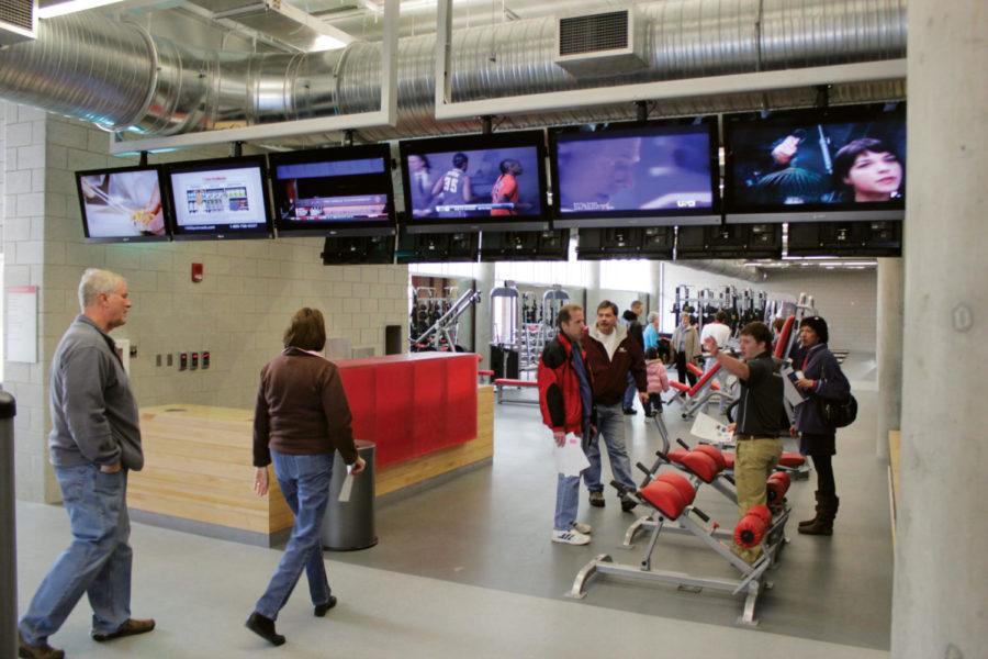 Visitor are given a tour of the weight-lifting equipment,
flanked by a row of televisions, during an open house on Sunday
Jan. 8, at State Gym. Unlike Lied Recreation Center, State Gyms
weight equipment has its own dedicated area on the lower level,
while all cardio equipment is located upstairs. 
