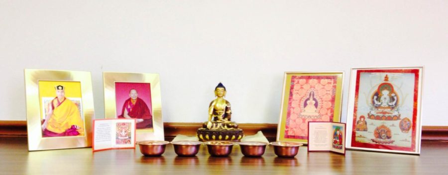Shakyamuni Buddha, a historical figure, is always central and with water offerings. The Karmapa, on the left, is the head of Karma Kagyu lineage — similar in importance to the Dalai Lama. The shrine must represent the body, speech and mind of the Buddha to be represented for it to be a true shrine.