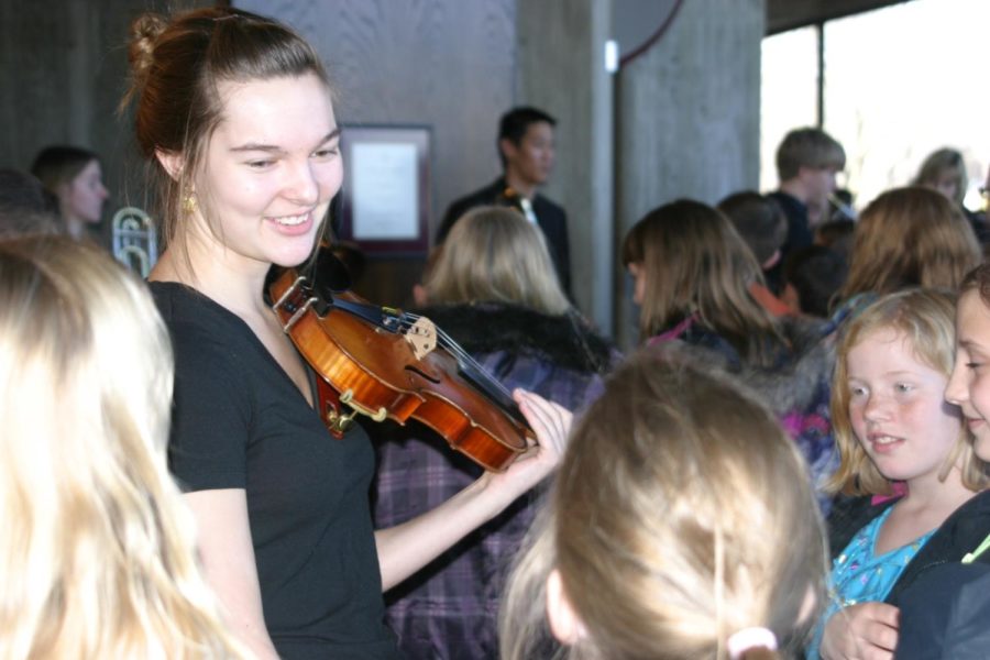 Students interact with ISU Symphony members at an instrument petting zoo, where students observe the instruments close-up as part of the Youth Matinee Series program.