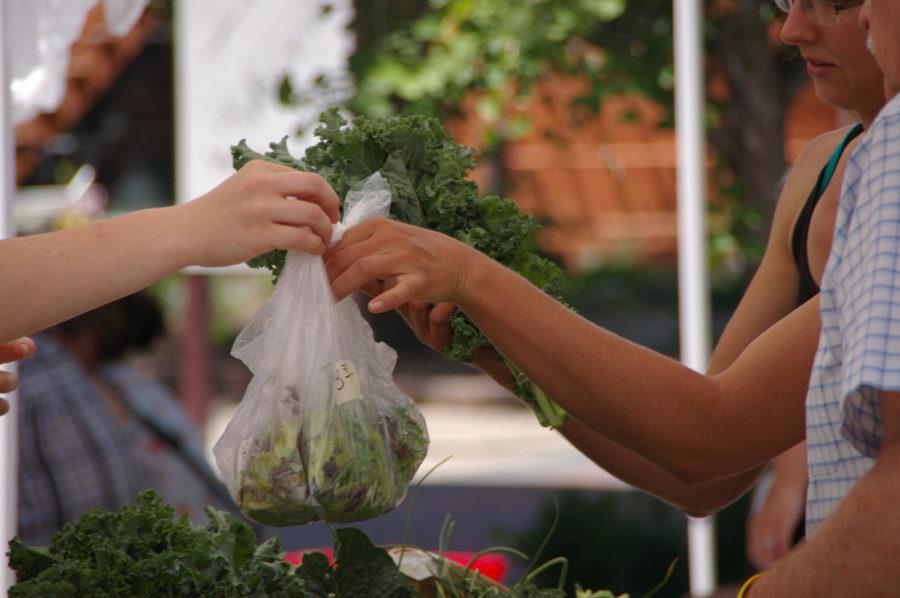 A+customer+buys+kale+and+a+garden+blend+salad+from+one+of+the+vendors+at+the+Ames+Main+Street+Farmers+Market+in+June+2014.
