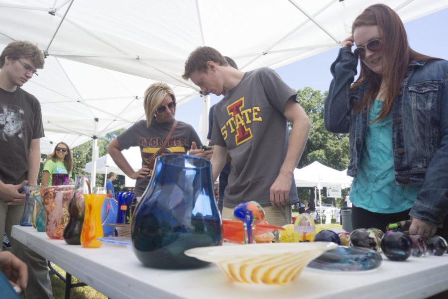 Students and families examine glass work at the Gaffers Guild stand at the Cyclone Market on Sept. 7 at Richardson Court.