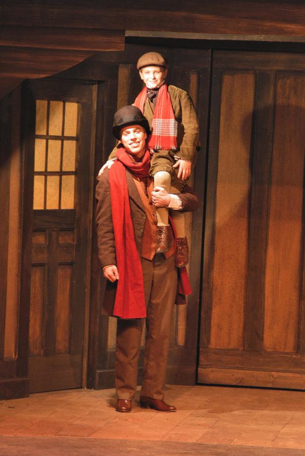 Bob Cratchit, who works for Ebenezer Scrooge, with his youngest child, Tiny Tim who walks with a crutch but still has a happy heart.