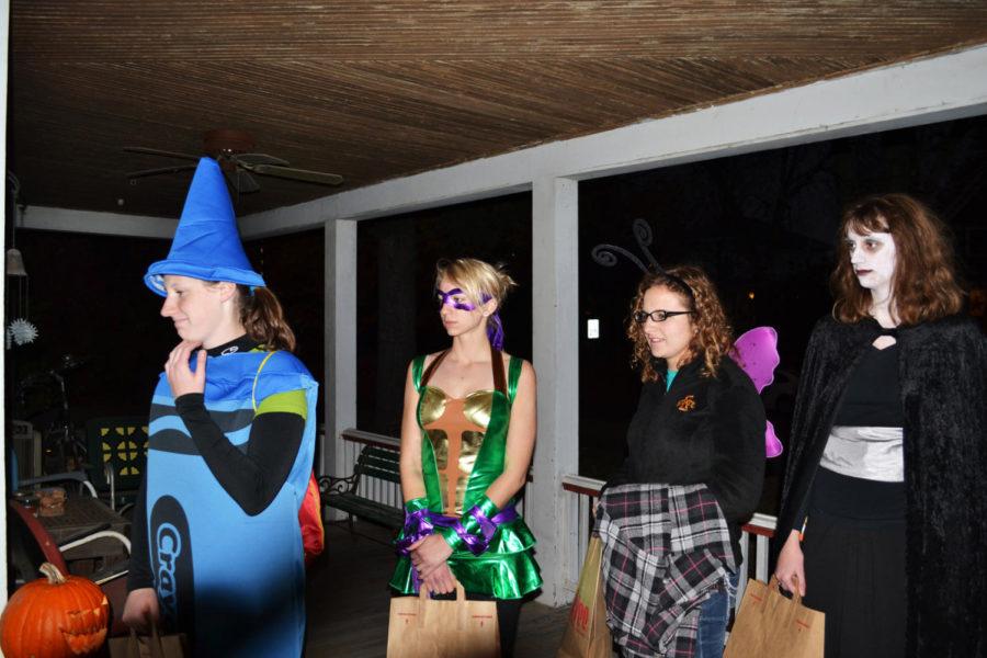 Emily Whitemarsh, freshman in engineering, Alex Burrett,
freshman in animal science, Kelsey Schieltz, freshman in chemical
engineering, and Vicky Pohlen, freshman in genetics, wait for young
trick-or-treaters to fill up on candy.

