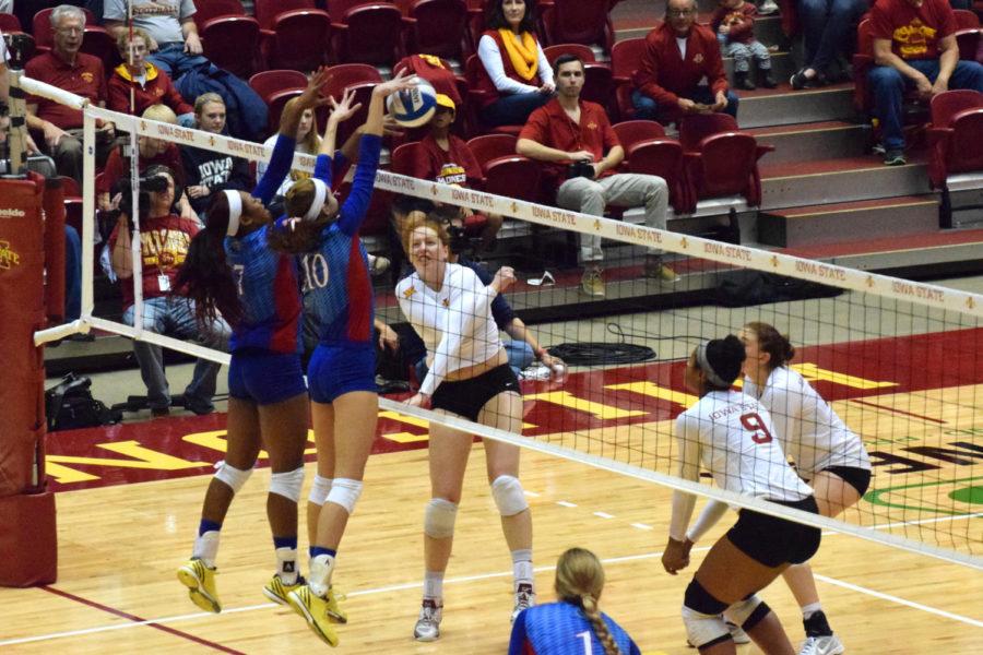 Junior right side hitter Mackenzie Bigbee gets blocked by Kansas outside hitter Tiana Dockery (left) and middle blocker Tayler Soucie (right) on Oct. 22.