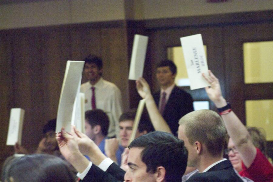 Senators raise their place cards as a form of voting at the Government of the Student Body Meeting on Wednesday, Oct. 15. 