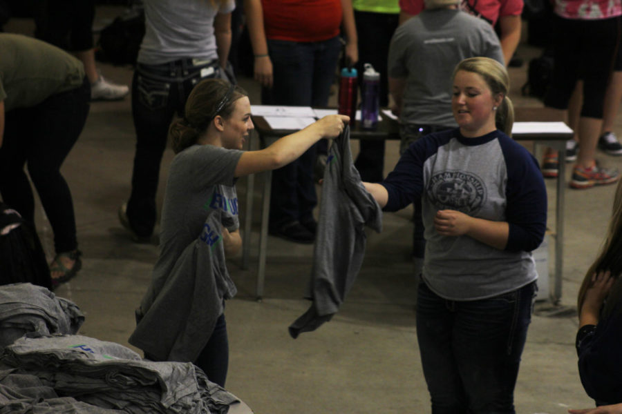 One of the co-chairs hands out t-shirts to the volunteers at the Block and Bridle Hunger Fight philanthropy on Sept. 30 in the Kildee Hall pavilion.