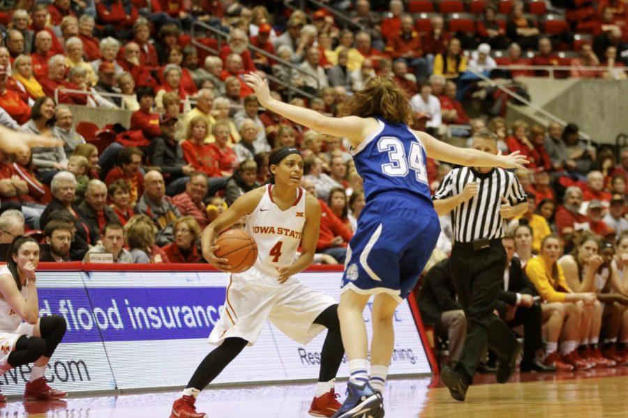 Senior guard Nikki Moody looks for a teammate to pass the ball as she dribbles across a Drake defender. Moody was two rebounds away from a triple double with eight rebounds, 18 points and 12 assists. Iowa State defeated Drake 84-67 on Nov. 18. 