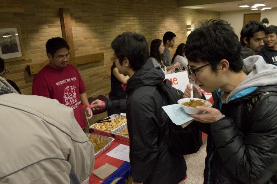 Students trade in tickets and enjoy samples at the Association of Malaysian Students at ISU booth. The booth was set up in the St. Thomas Aquinas Church for an International Foods night on Nov. 13. The event served as a fundraiser for many international student organizations at ISU.