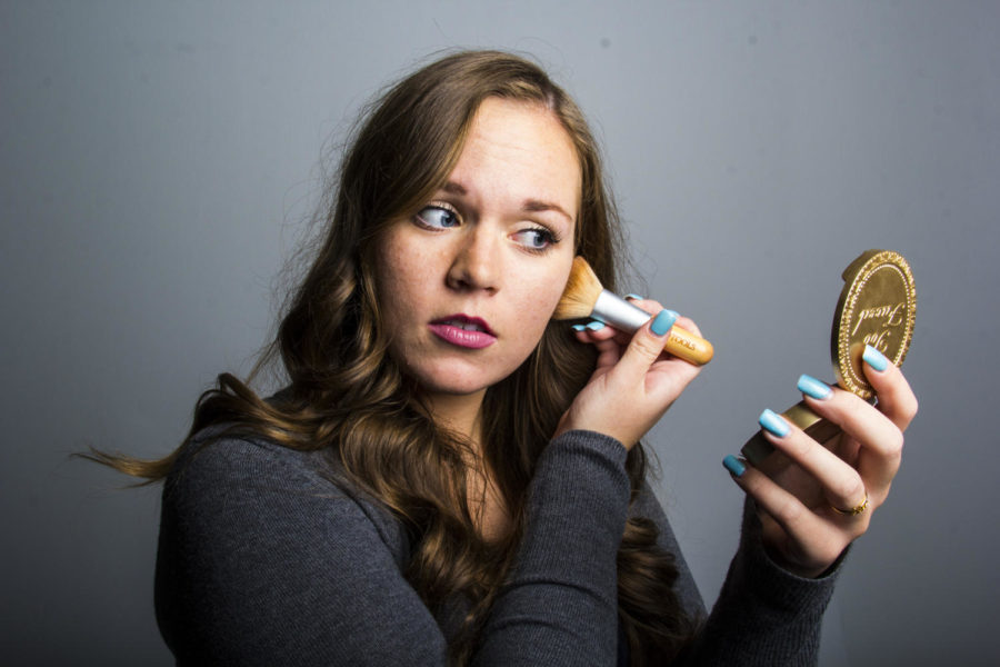 Laura Campbell, freshman in pre-business, uses a powder bronzer to add color to her fair winter skin.