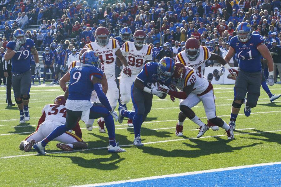 Members of the ISU defense attempt to take down running back Corey Avery on Nov. 8 at Lawrence, Kan. Iowa State fell to the Jayhawks 34-14.